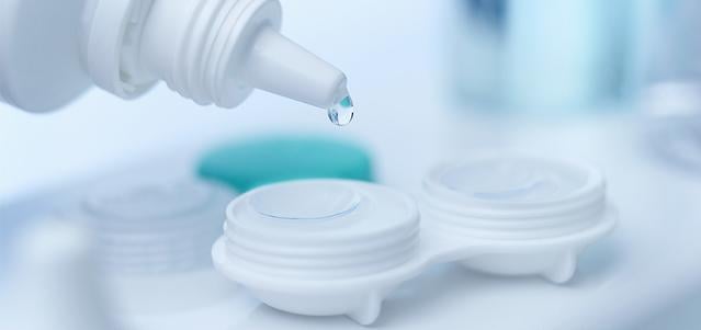 Close up of a contact lens case and cleaning solution.