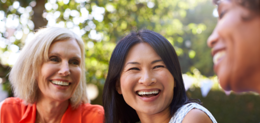 Image of three diverse women talking and laughing with eachother